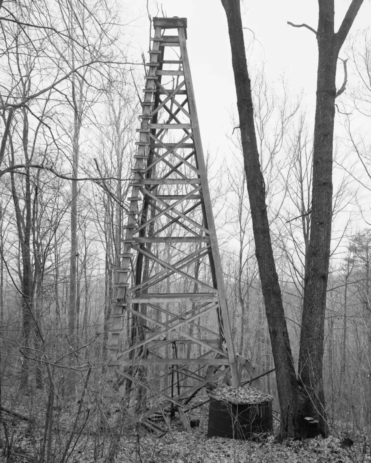 Oil and gas in West Virginia: a wooden frame oil derrick standing among bare trees in Ritchie County, West Virginia, in 1973