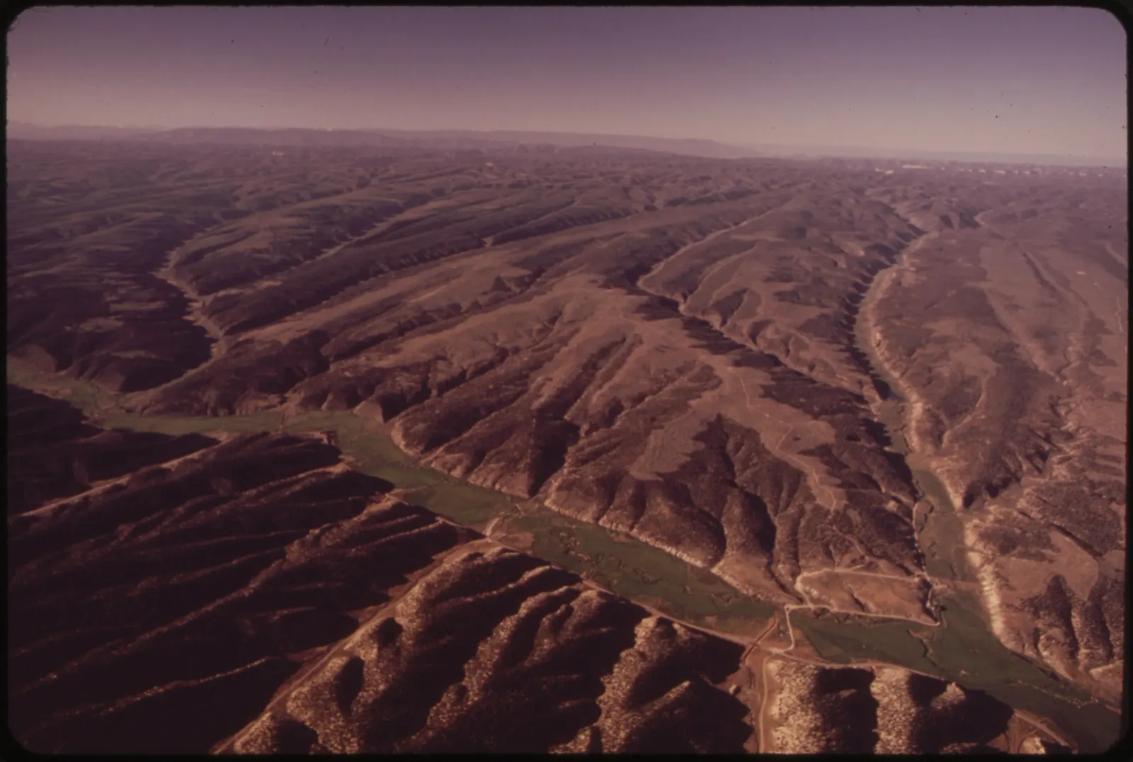 Aerial view over Piceance Creek toward federal oil shale lease tract C-b in western Colorado, 1973