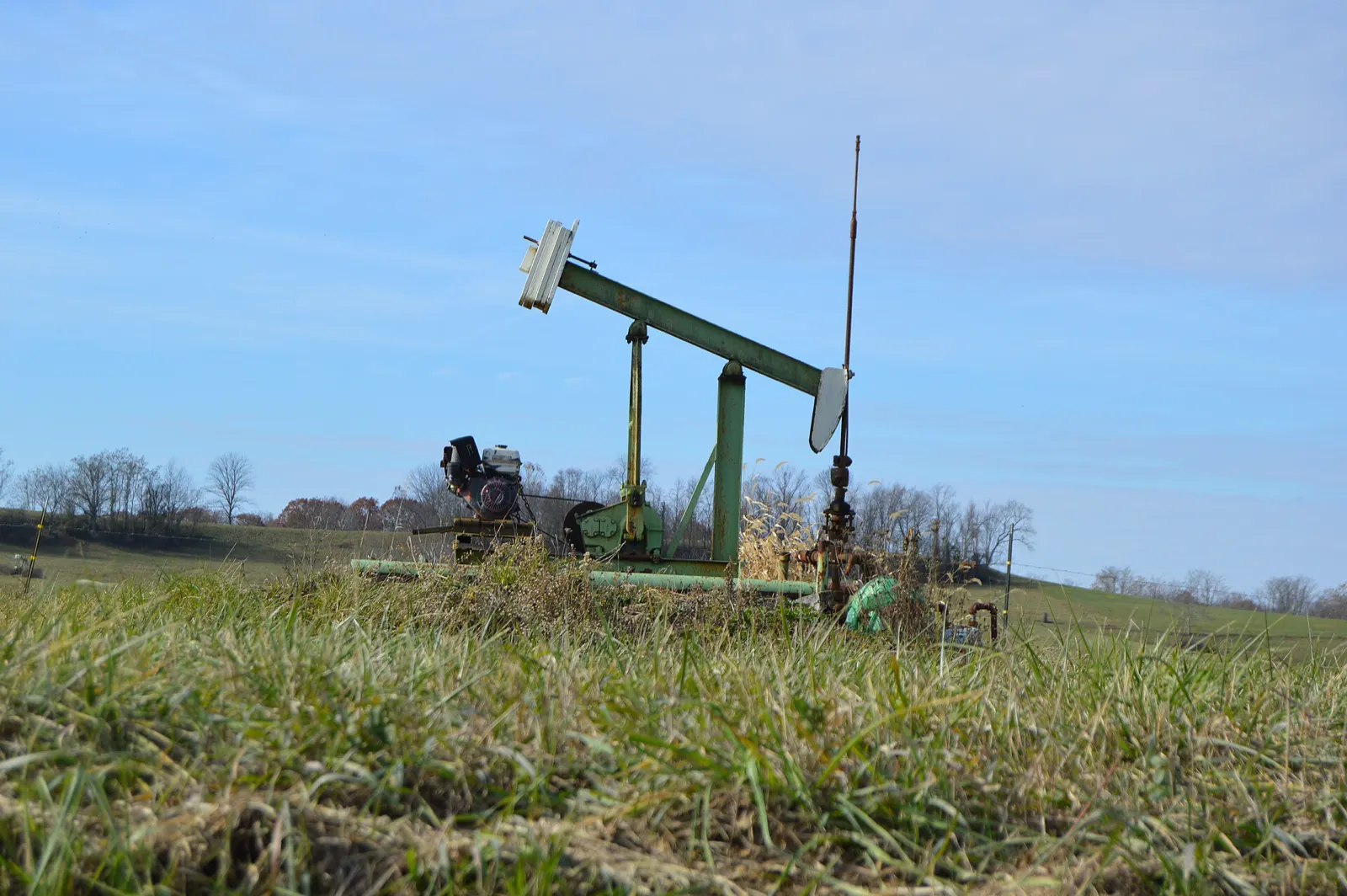 Sell mineral rights in Ohio: a small pumpjack in a grassy field in Morgan County, Ohio