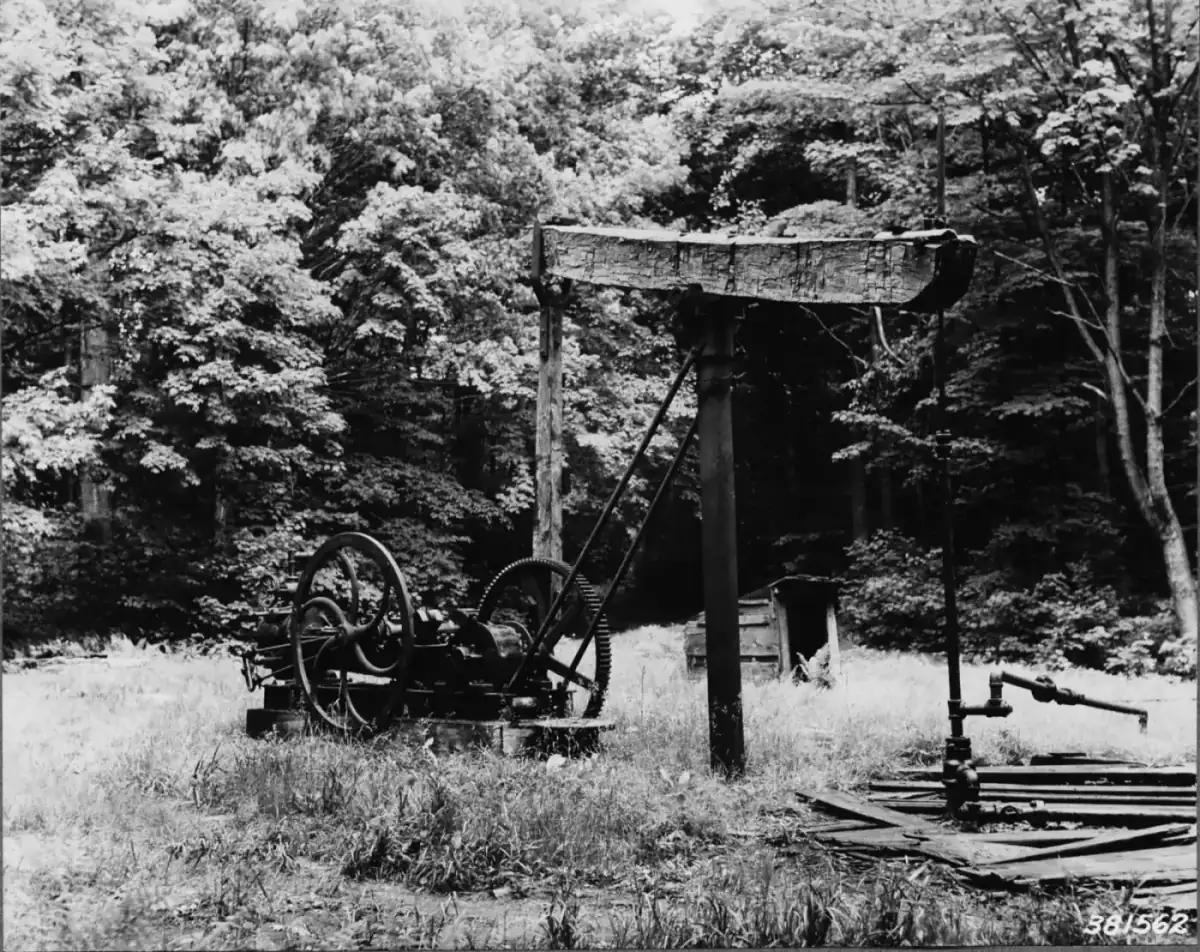 A gas-powered engine and timber walking beam pump at an old oil well in the Allegheny National Forest, Pennsylvania, in 1939